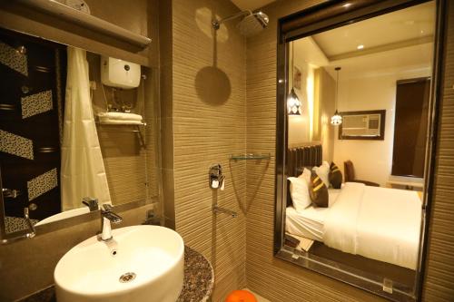 baño con lavabo y ducha con cama en Hotel D SilverLeaf, en Lucknow