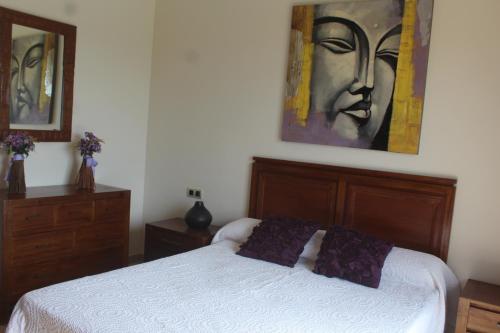 a bedroom with a bed and a painting on the wall at VILLA RAQUEL in Yaiza