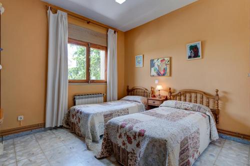 two beds in a room with yellow walls at Finca Victoriana Riaza in Riaza
