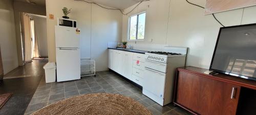 a kitchen with a refrigerator and a stove at AAOK Lakes Resort and Caravan Park in Berry Springs