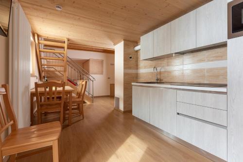 a kitchen with a staircase and a dining room at Hotel Meublè Adler - Rooms & Mountain Apartments in Santa Caterina Valfurva