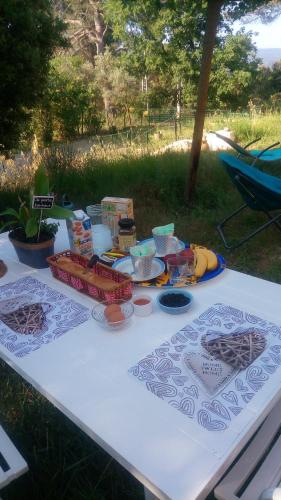 ein weißer Tisch mit Essen darüber in der Unterkunft Les Cigales in Villelaure