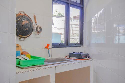 a kitchen with a sink and a window at OYO 90352 Villa Agape 2 in Cianjur