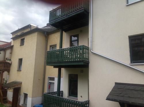 a building with green balconies on the side of it at Ferienwohnung Rickyy in Reichenbach im Vogtland