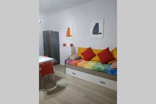 sypialnia z łóżkiem z kolorowymi poduszkami w obiekcie Feel at Home - CASA LA POSTA w mieście Lovere