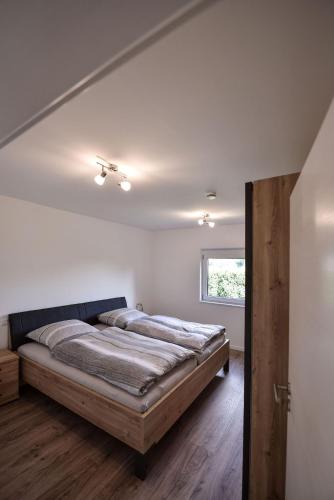 a bedroom with a bed and a window at Steinbrunner Geschmackvolle Ferienwohnungen in Burghausen