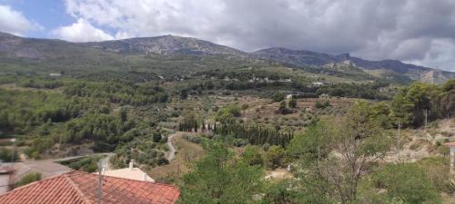 a view of a mountain with trees and a house at Apartamento La Coveta de Guadalest in Guadalest