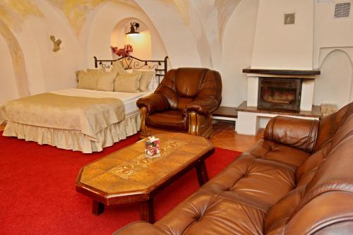 a living room with a bed and leather furniture at Vivaldi Apartments in Mikulov