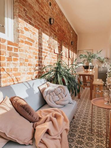 a couch sitting in a room with a brick wall at Apartamenty Rajcza in Rajcza