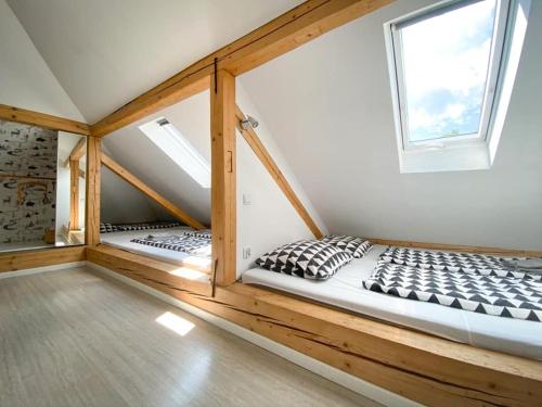 a room with two beds in a loft with a window at Apartamenty Rajcza in Rajcza