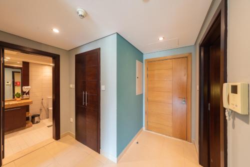 a bathroom with a blue wall and a door at One Bedroom in Burj Views by Radiance Vacation Stays in Dubai
