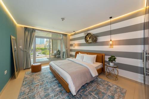 a bedroom with a bed with a striped wall at One Bedroom in Burj Views by Radiance Vacation Stays in Dubai
