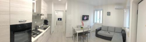 a white kitchen with a table and a counter top at casa bob alloggio turistico in Fondi