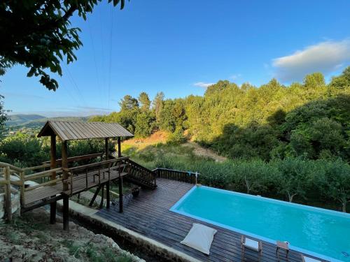 a wooden deck with a pool and a gazebo at Quinta das Ameixas - Country & Nature in Arouca