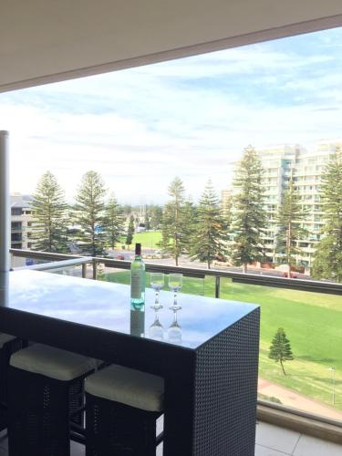 a table with two glasses and a bottle of wine at Beachside Luxury Apartments One & Two Bedroom in Beachfront Oaks Pier Building in Glenelg
