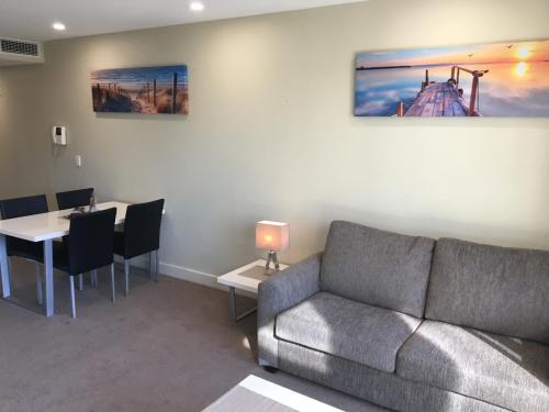 a living room with a couch and a table at Beachside Luxury Apartments One & Two Bedroom in Beachfront Oaks Pier Building in Glenelg