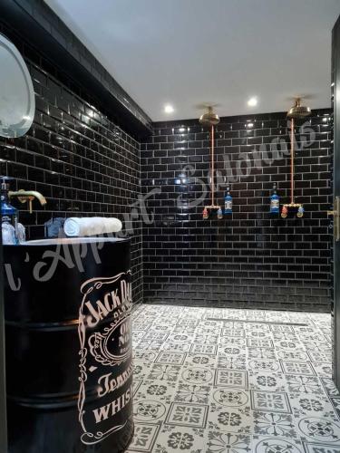 La salle de bains est pourvue d'un lavabo et d'un mur en briques noires. dans l'établissement Lappart-salonais 70m2 avec jacuzzi privatif, à Salon-de-Provence