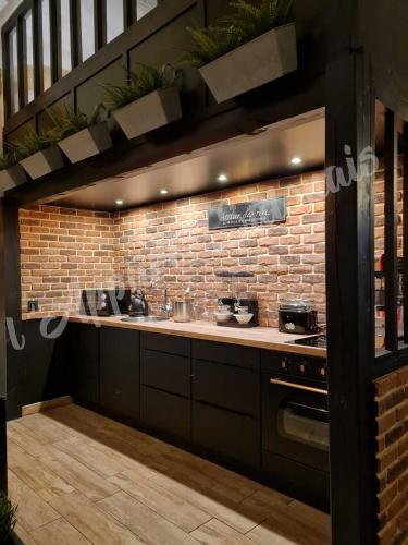 - une cuisine avec un évier et un mur en briques dans l'établissement Lappart-salonais 70m2 avec jacuzzi privatif, à Salon-de-Provence