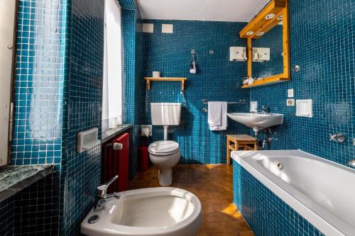 a bathroom with a tub and a toilet and a sink at Hotel Cristallo in Courmayeur