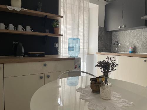 a kitchen with a glass table with a vase of flowers at The 2Sisters Suite in Zadar