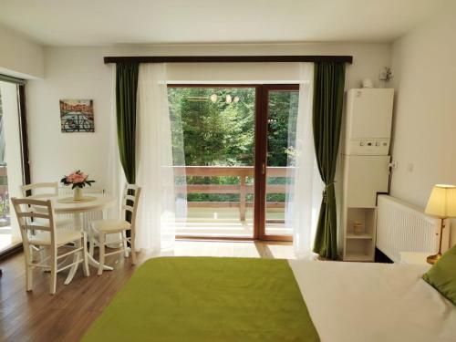 a living room with a bed and a table and a window at Green Studio in Predeal