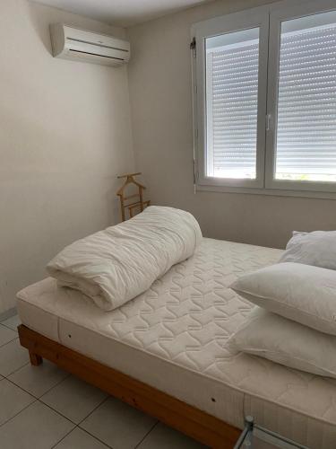 une chambre avec deux lits et une fenêtre dans l'établissement Appt avec parking, clim, wifi à 50 m de la plage, à Palavas-les-Flots