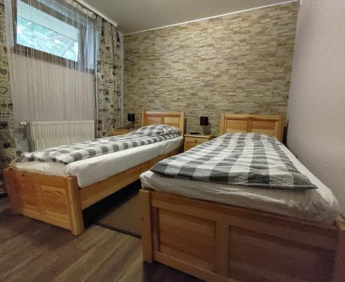 two beds in a bedroom with a brick wall at Villa Maja in Zakopane