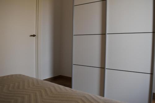 a bedroom with white cabinets and a bed at APARTAMENTO EL ROMERAL in Alhaurín de la Torre