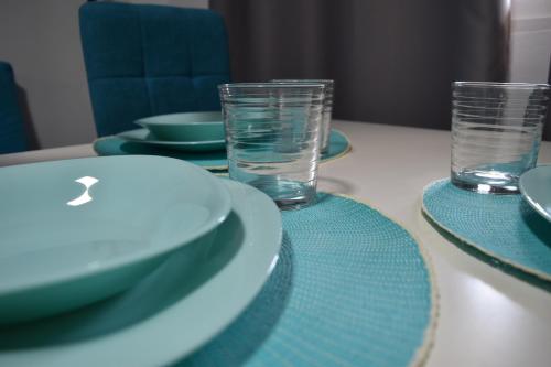 a table with plates and glasses on top of it at APARTAMENTO EL ROMERAL in Alhaurín de la Torre