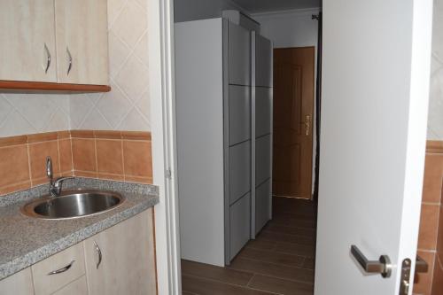 a kitchen with a sink and a door to a hallway at APARTAMENTO EL ROMERAL in Alhaurín de la Torre