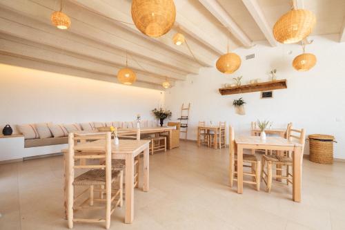 a restaurant with wooden tables and chairs and a couch at Agroturismo Ses Talaies in Ciutadella