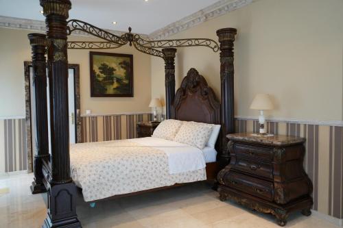 - une chambre avec un lit à baldaquin noir et une commode dans l'établissement Rural Palace, à Sopuerta