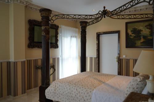 a bedroom with a canopy bed and a window at Rural Palace in Sopuerta