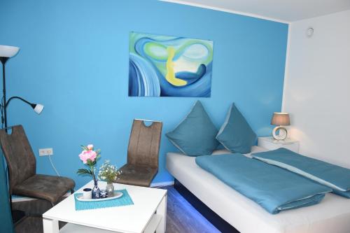 een blauwe slaapkamer met een bed en 2 stoelen bij Top-Moderne und geräumige Ferienwohnung in Aßling