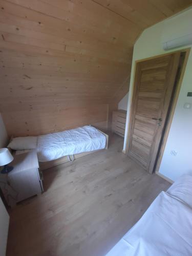a small bedroom with two beds and a closet at Leśny Zakątek Radocza in Radocza