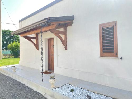 a building with a porch with a wooden awning at Villetta al mare Scanzano Jonico in Scanzano