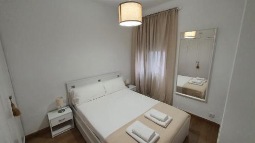 a white bedroom with a bed and a mirror at Opening Doors Sagrada Familia in Barcelona