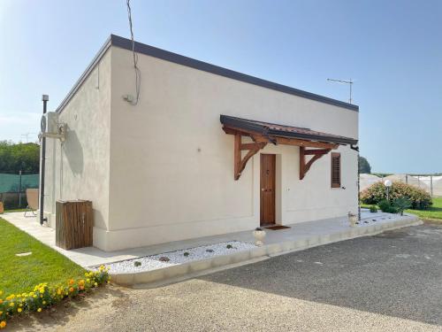a white building with a wooden door on it at Villetta al mare Scanzano Jonico in Scanzano
