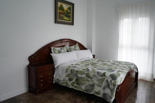 a bedroom with a bed with a wooden headboard and a window at Rural Palace in Sopuerta