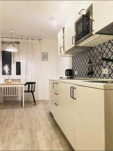 a kitchen with a stove, sink and refrigerator at Apartamenty Centrum in Warsaw