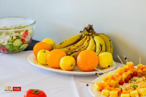 a plate of bananas oranges and other fruits on a table at Douglas Lodge & Apartments in Lilongwe