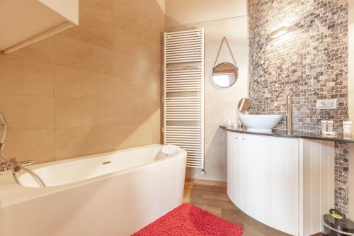 a bathroom with a white tub and a sink at House of Bruges in Bruges
