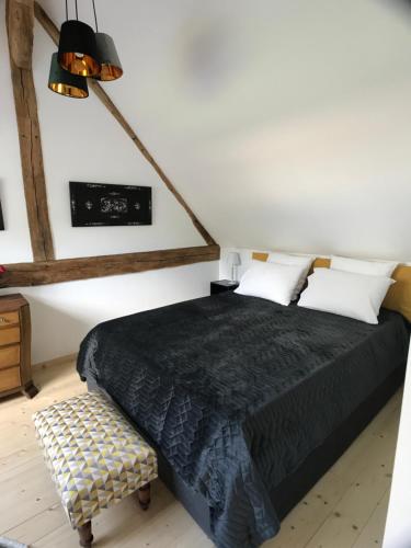 ein Schlafzimmer mit einem Bett mit einer schwarzen Bettdecke in der Unterkunft GITE DU MANOIR DE MONTEAN in Dame-Marie