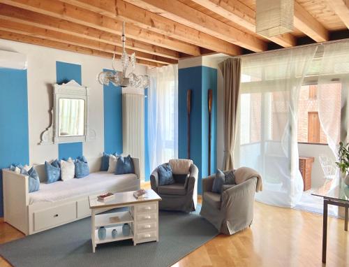 a living room with blue walls and a couch and chairs at Lagoon Secret Venice in Venice