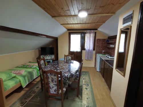uma sala de jantar com uma mesa e uma cama em Apartman Jaredić - Private Accommodation, Privatni Smeštaj em Donji Milanovac