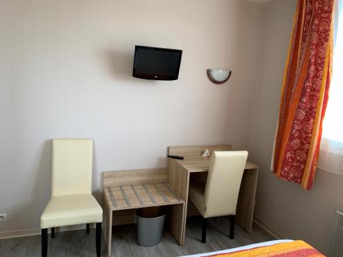 a room with a table and two chairs and a tv at Hotel du Haut Marais in Saint-Marcel