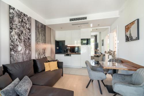 - un salon avec un canapé et une salle à manger dans l'établissement Spa Residence Carbona Hévíz Apartments KAKADU 203 A, à Hévíz