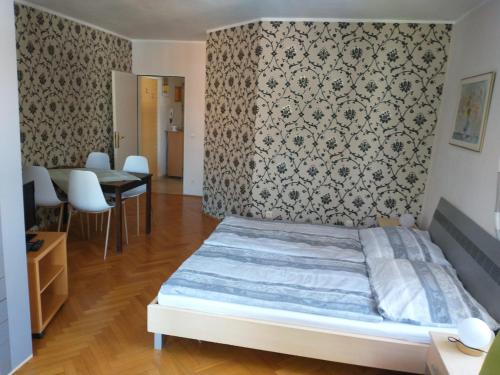 1 dormitorio con 1 cama, mesa y sillas en Ferienwohnung Madlene 1, en Gablitz