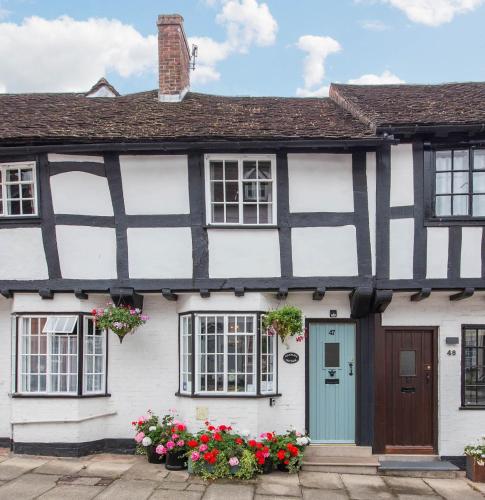 a black and white house with flowers in front of it at Charlie's Cottage in Ludlow