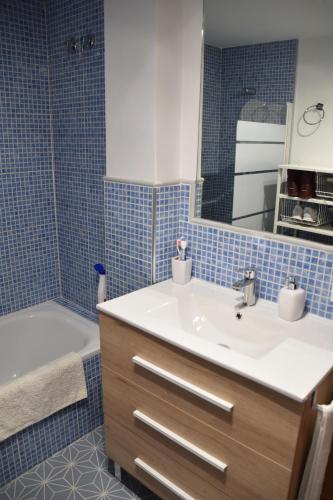a bathroom with a sink and a tub and a mirror at Apartamento Plaza de Pradollano - Parking incluido in Sierra Nevada